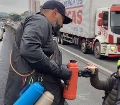 Garrafas térmicas enfileiradas no guard-rail: ambulante que vende café na Anhanguera conquista clientes e viraliza